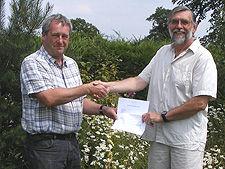 Woodford Community Council Photo competition winner Kris Hayward receiving details of the prize from WCC Chairman Paul Rodman