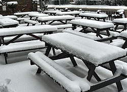 A photo of outdoor picnic seats covered in snow at the Thieves Neck pub in Woodford, Cheshire taken by Kris Hayward