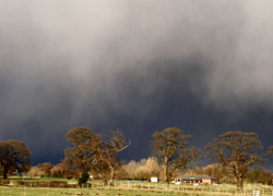 A photograph of a storm brewing over the cricket pitch at Woodford in Cheshire